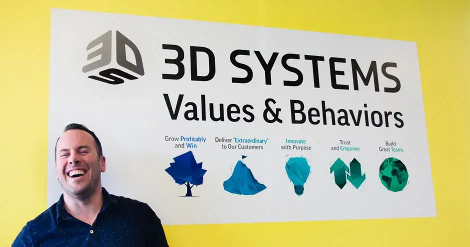 3D Systems colleague in front of a 3D Systems poster