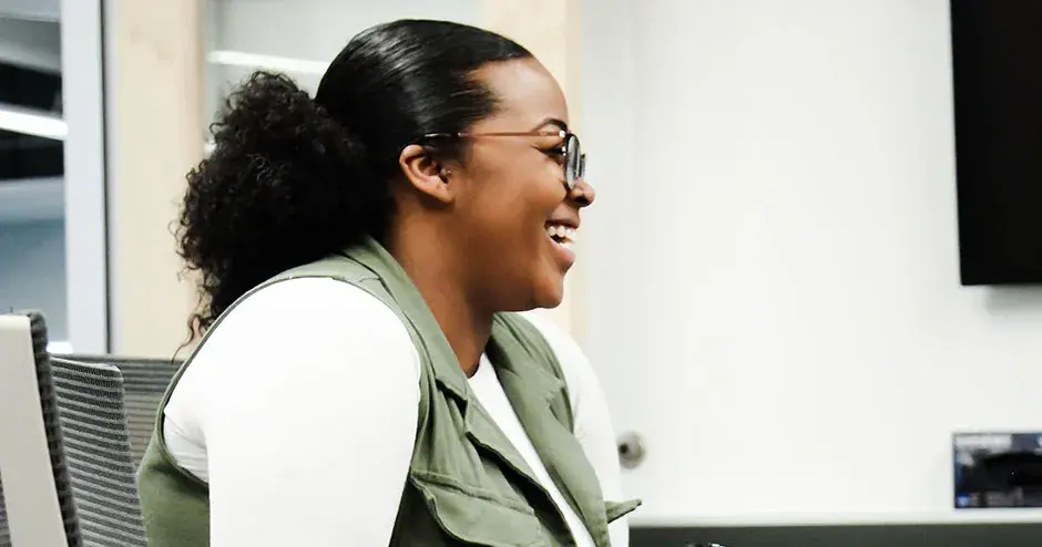 un colega sentado en una mesa, sonriendo
