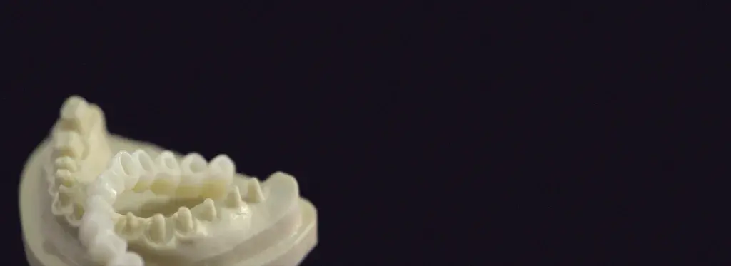 3D printed dental molds on a dark background