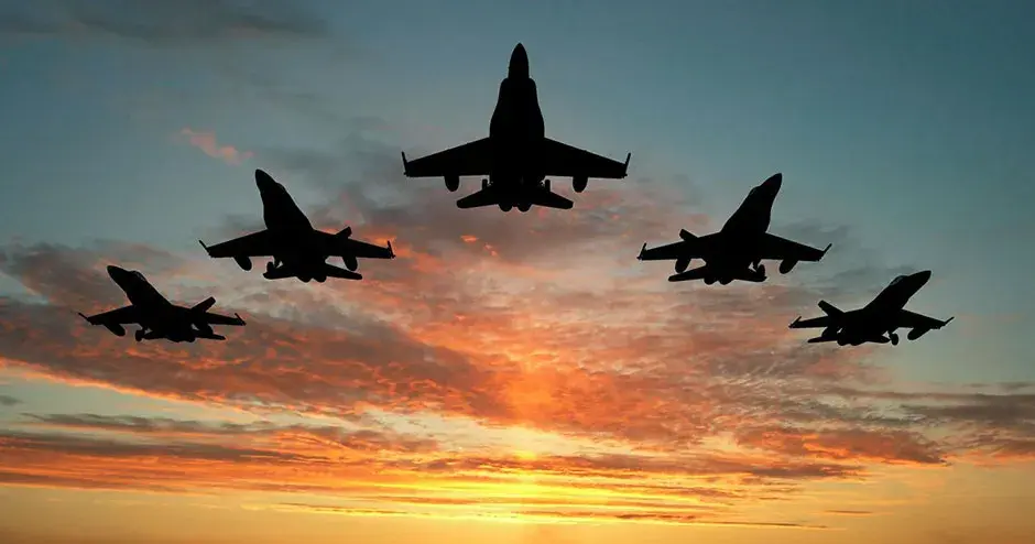 5 aviones volando en fila al atardecer