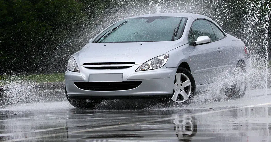 Un automóvil atravesando un charco y ocasionando una salpicadura gigante