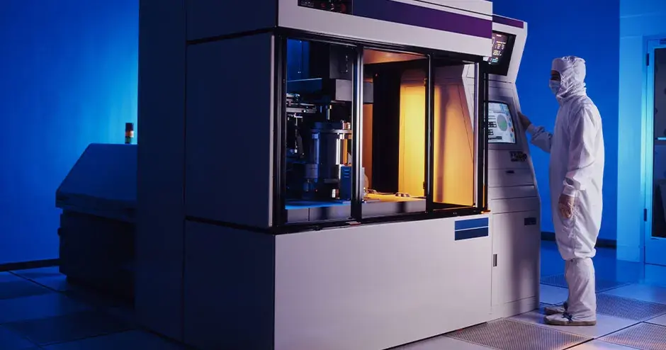 una persona de pie al lado de una impresora 3D