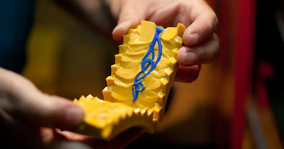 pendiente de cera azul en un molde de caucho amarillo