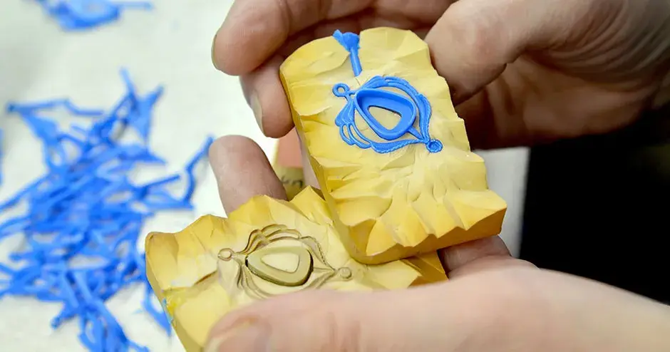 pendiente de cera azul y bisel triangular y redondeado en un molde de caucho amarillo