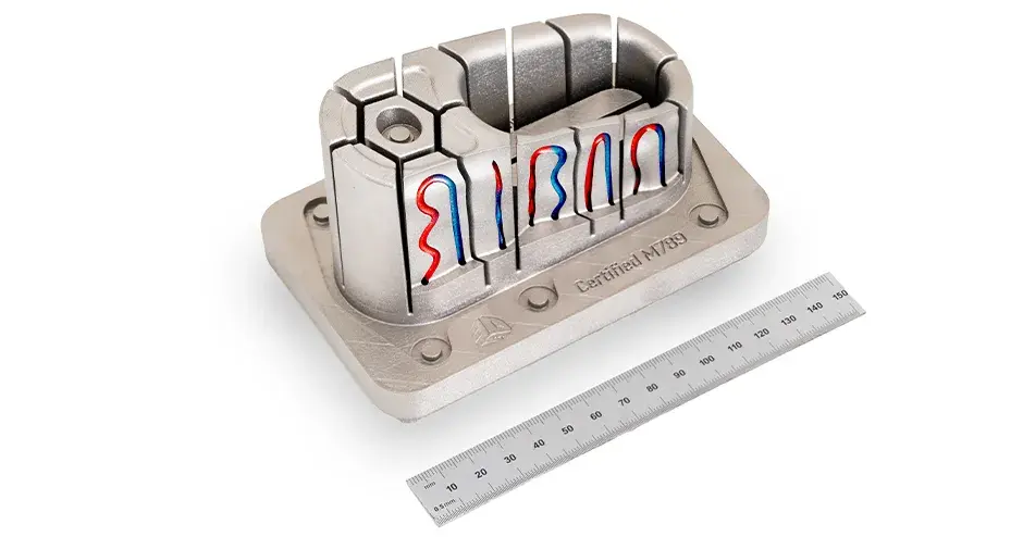 A mold insert air vent with conformal cooling DMP tooling made from Certified M789 (A) placed next to a ruler to show the scale, 150mm