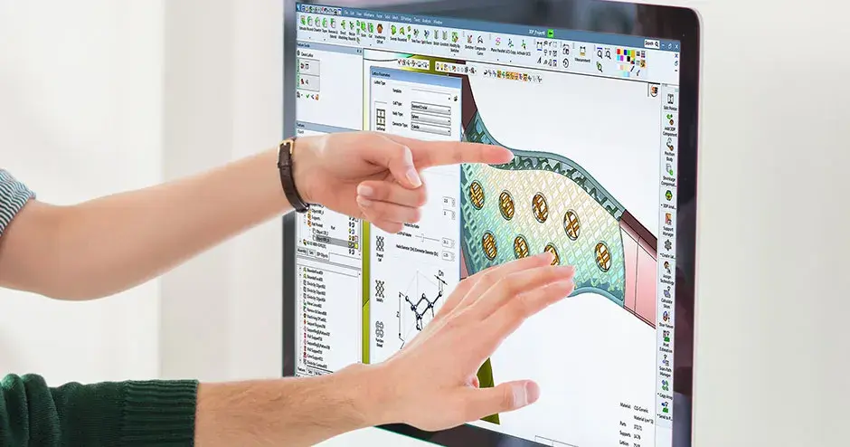 2 personas señalando el monitor de una computadora