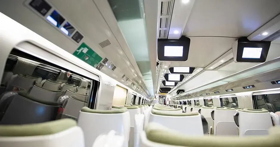 Interior moderno y brillante de un tren de pasajeros que muestra diversos materiales y acabados de la superficie para diferentes componentes