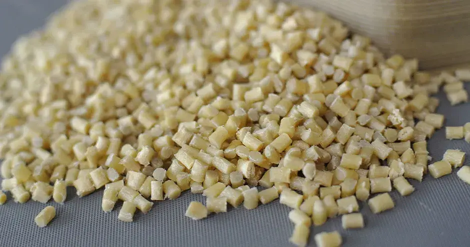 Pellets de plástico de color blanco sobre un fondo gris