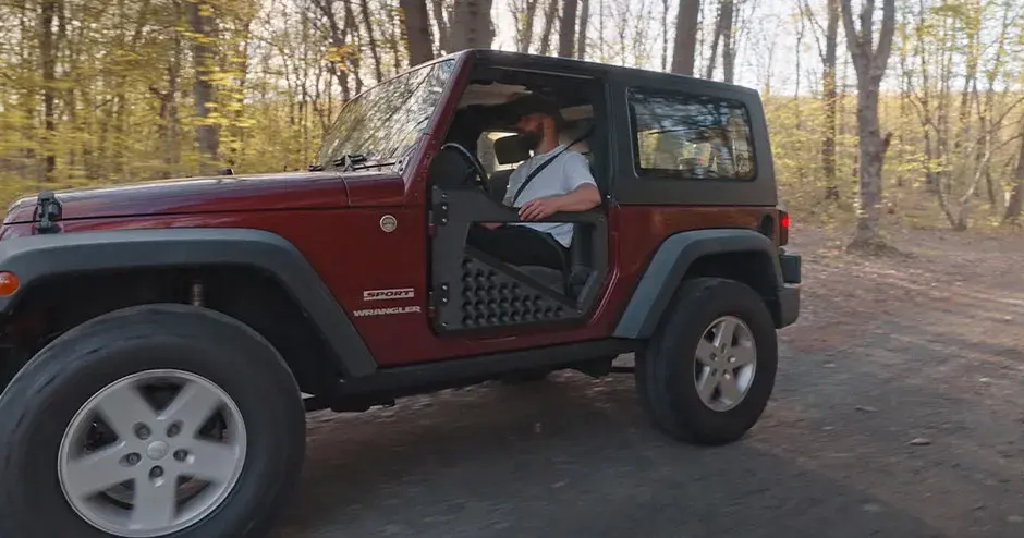 Un hombre sentado en un Wrangler, que tiene piezas hechas con una impresora 3D Atlas-H