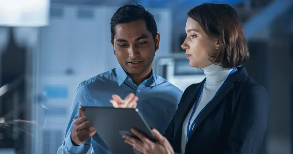 2 personas colaborando en una tableta en un entorno industrial