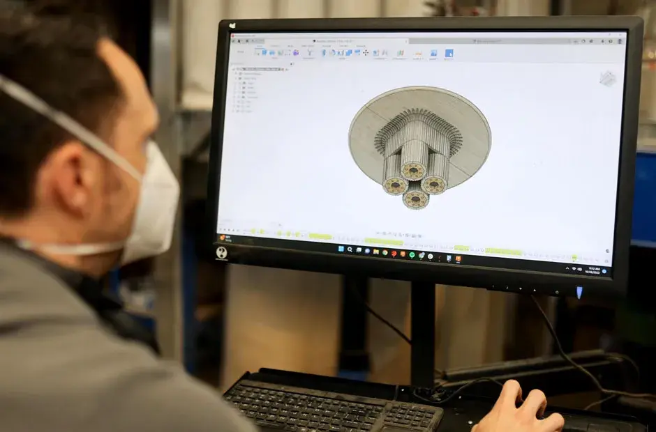 Una persona trabajando en un archivo CAD diseñando una silla